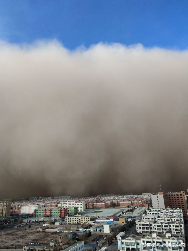 这是摄影师拍摄的甘肃张掖沙尘暴来袭的图片,远观"沙墙"遮天蔽日.